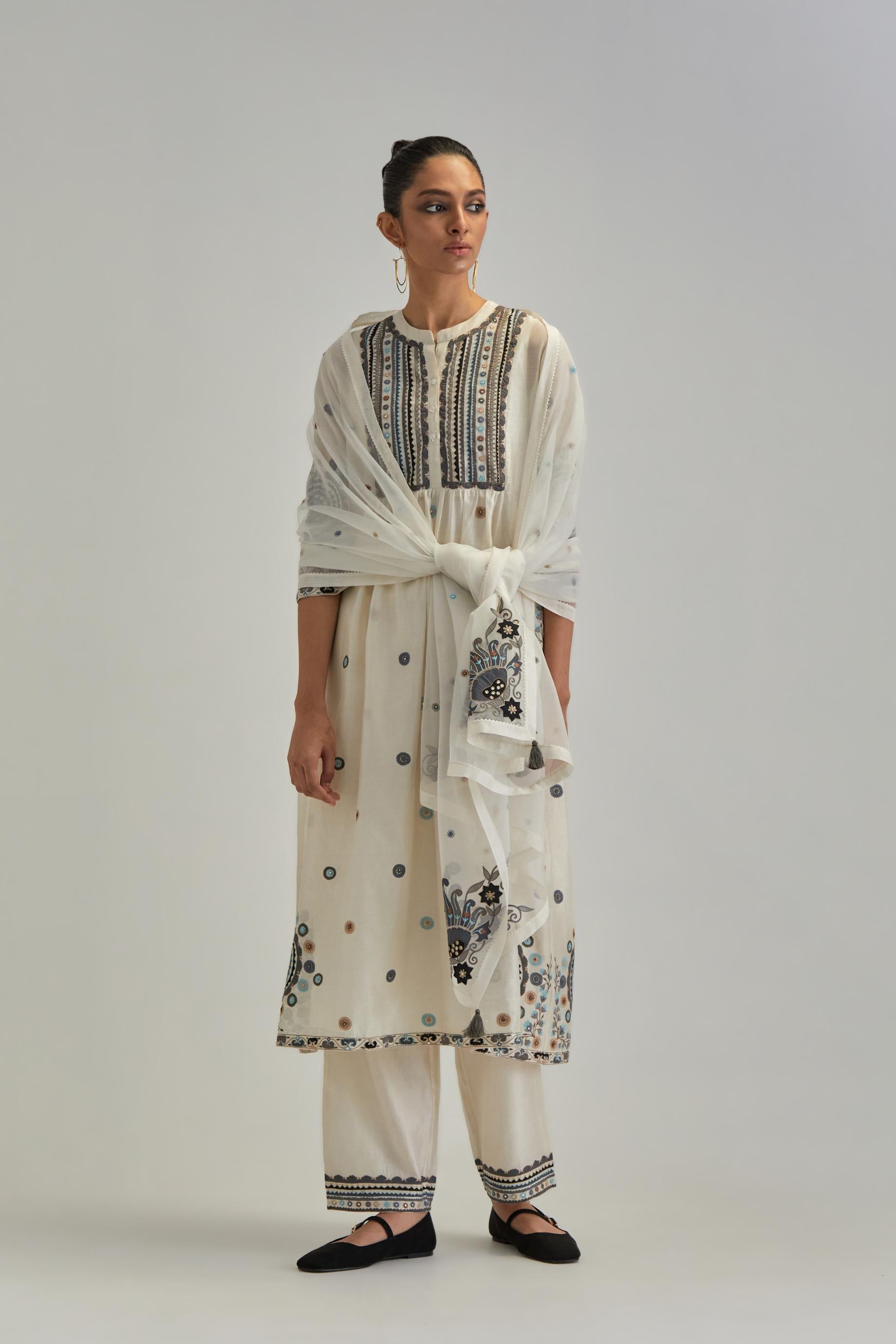 Off White silk Chanderi gathered kurta-dress set with appliqué stripes along with Aari thread work flowers and floral trellises along with a circular appliqued motif.