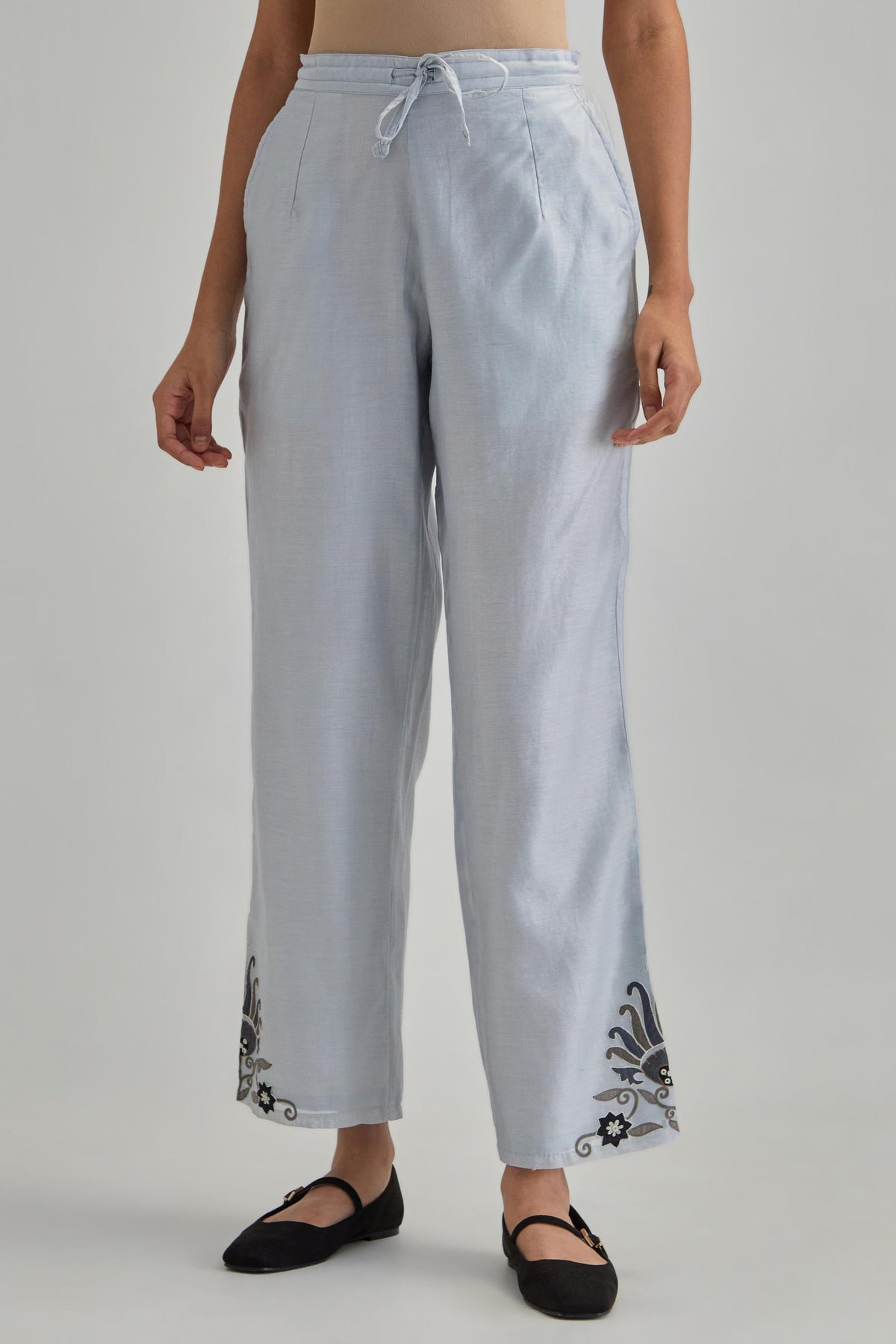 Blue silk Chanderi straight pants with earthy coloured appliqué at hem.