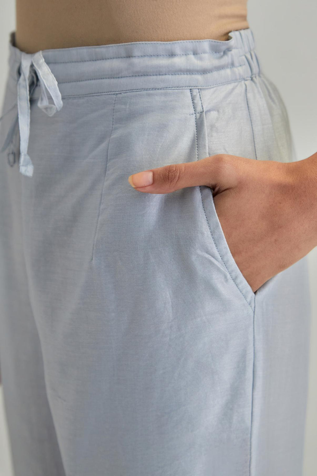 Blue silk Chanderi straight pants with earthy coloured appliqué at hem.
