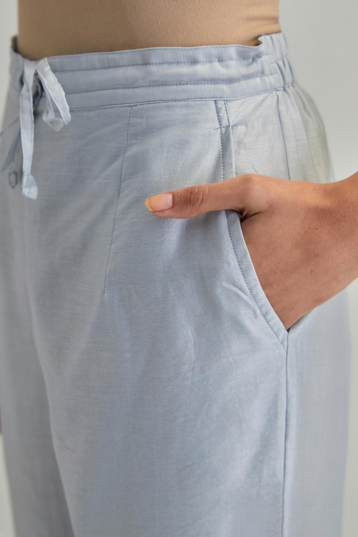 Blue silk Chanderi straight pants with earthy coloured appliqué at hem.
