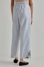 Blue silk Chanderi straight pants with earthy coloured appliqué at hem.