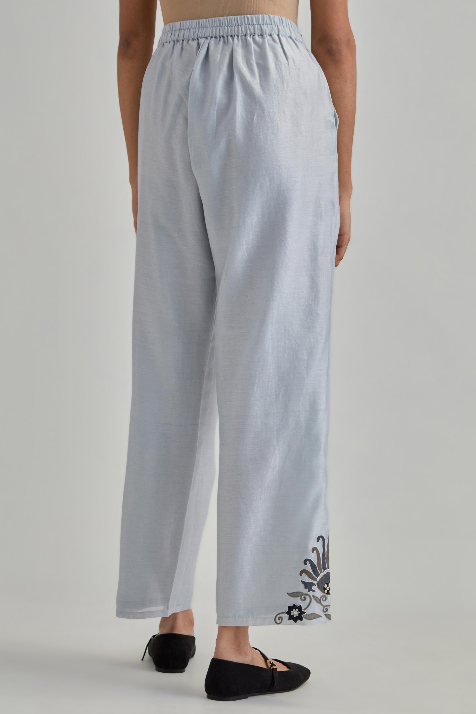 Blue silk Chanderi straight pants with earthy coloured appliqué at hem.