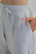 Blue silk Chanderi straight pants with earthy coloured applique and Aari thread work at hem.