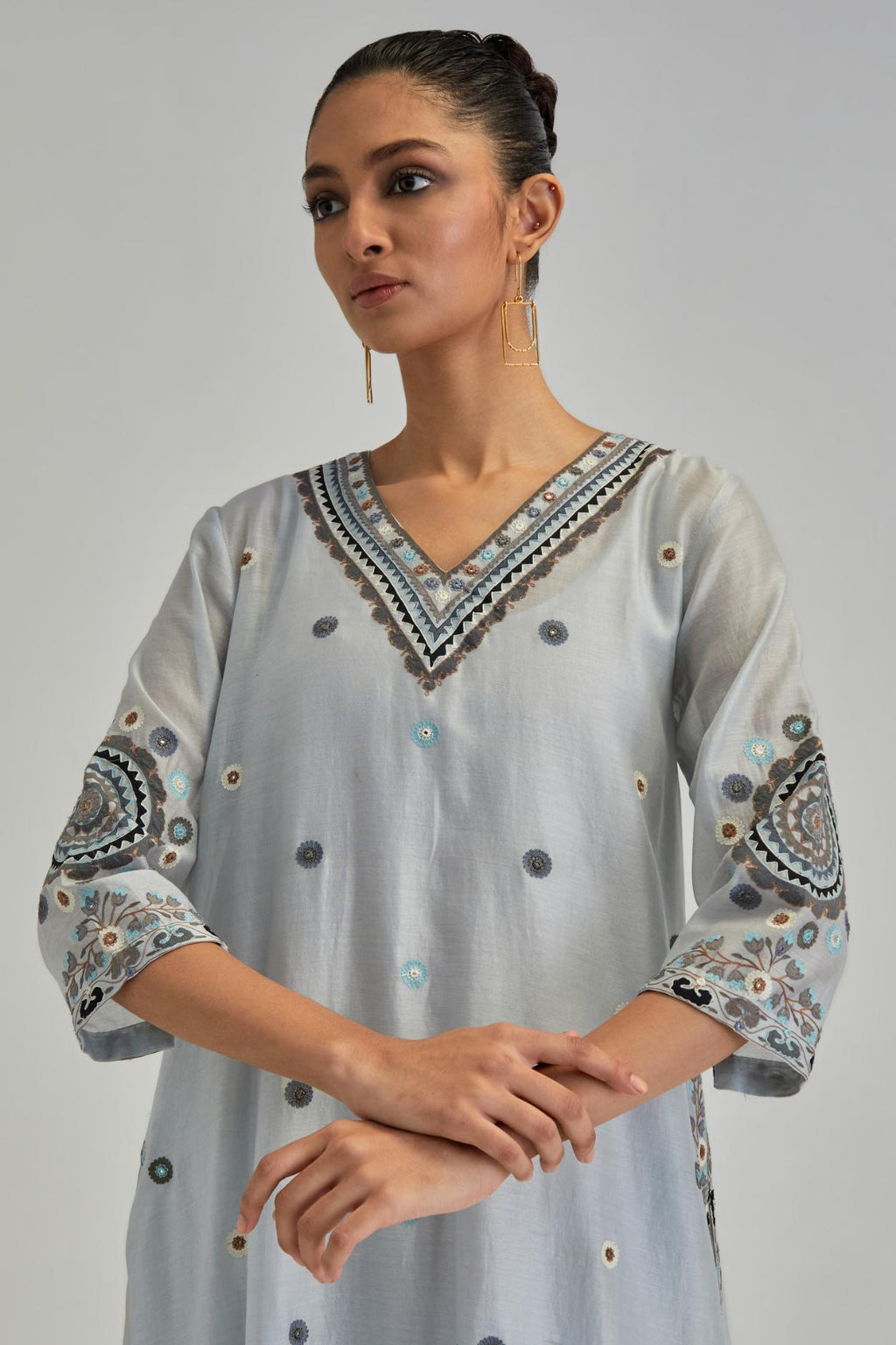 Blue silk Chanderi short V-neck kurta set, with straight hem and side pockets, decorated with fine appliqué and Aari thread embroidery.