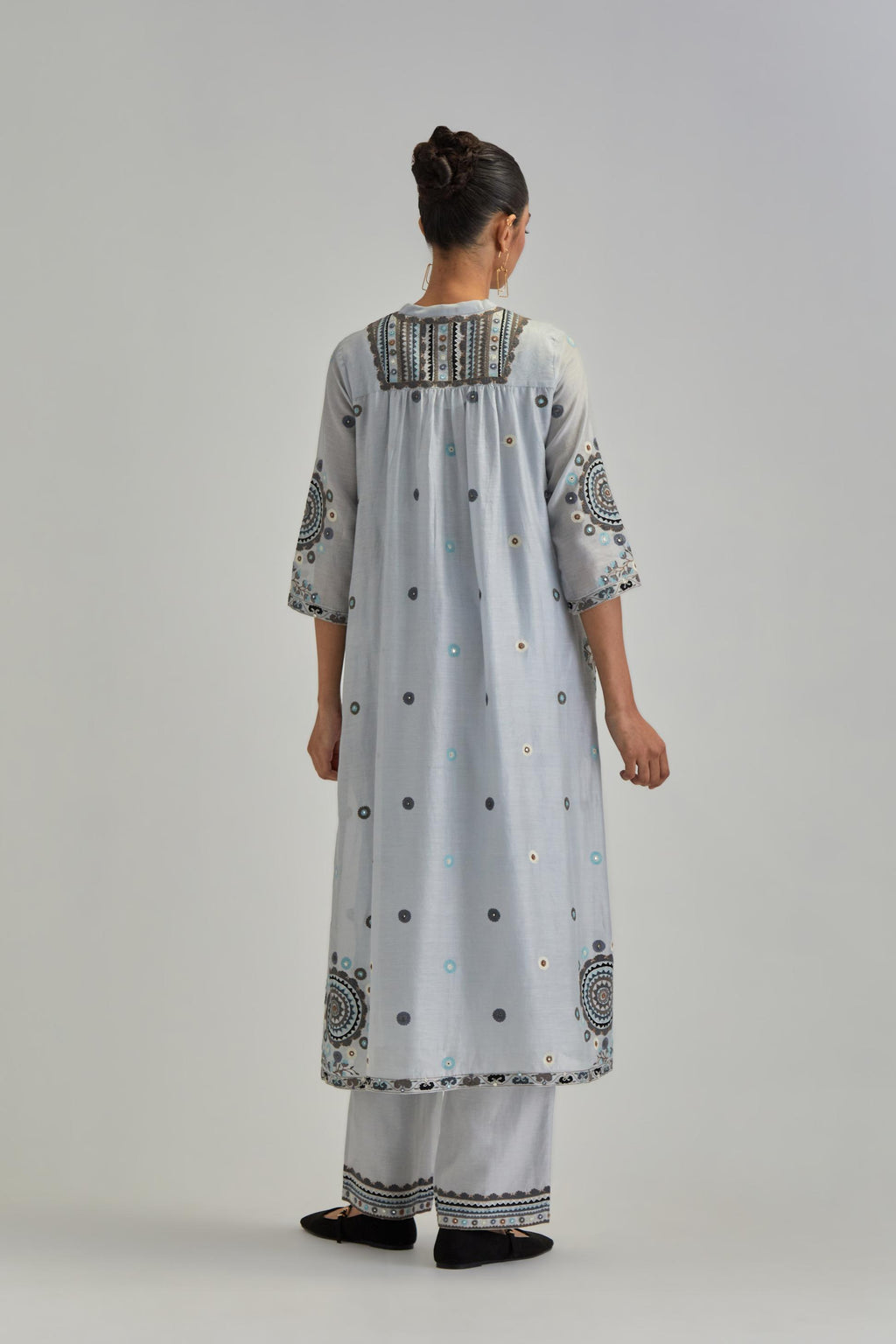 Blue silk Chanderi gathered kurta-dress set with appliqué stripes along with aari thread work flowers and floral trellises along with a circular appliqued motif.