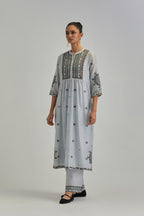 Blue silk Chanderi gathered kurta-dress set with appliqué stripes along with aari thread work flowers and floral trellises along with a circular appliqued motif.