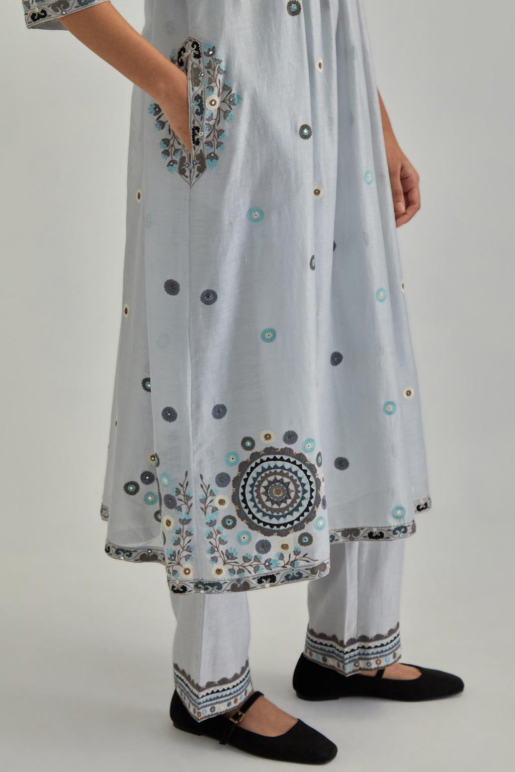 Blue silk Chanderi gathered kurta-dress set with appliqué stripes along with aari thread work flowers and floral trellises along with a circular appliqued motif.