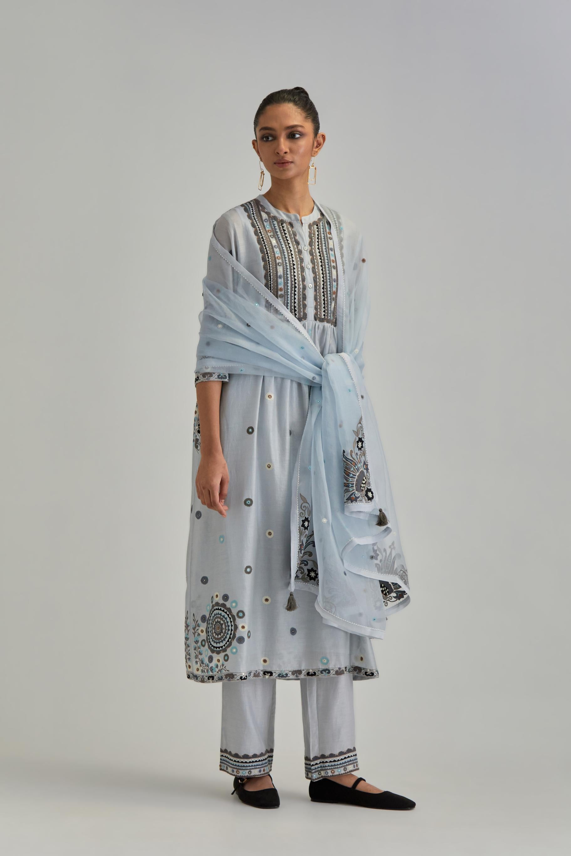 Blue silk Chanderi gathered kurta-dress set with appliqué stripes along with aari thread work flowers and floral trellises along with a circular appliqued motif.