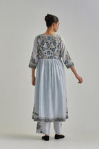 Blue silk Chanderi kurta-dress set with a wavy high-waist and fine gathers. The yoke is fully embroidered with earthy coloured circular appliqué and Aari thread work.