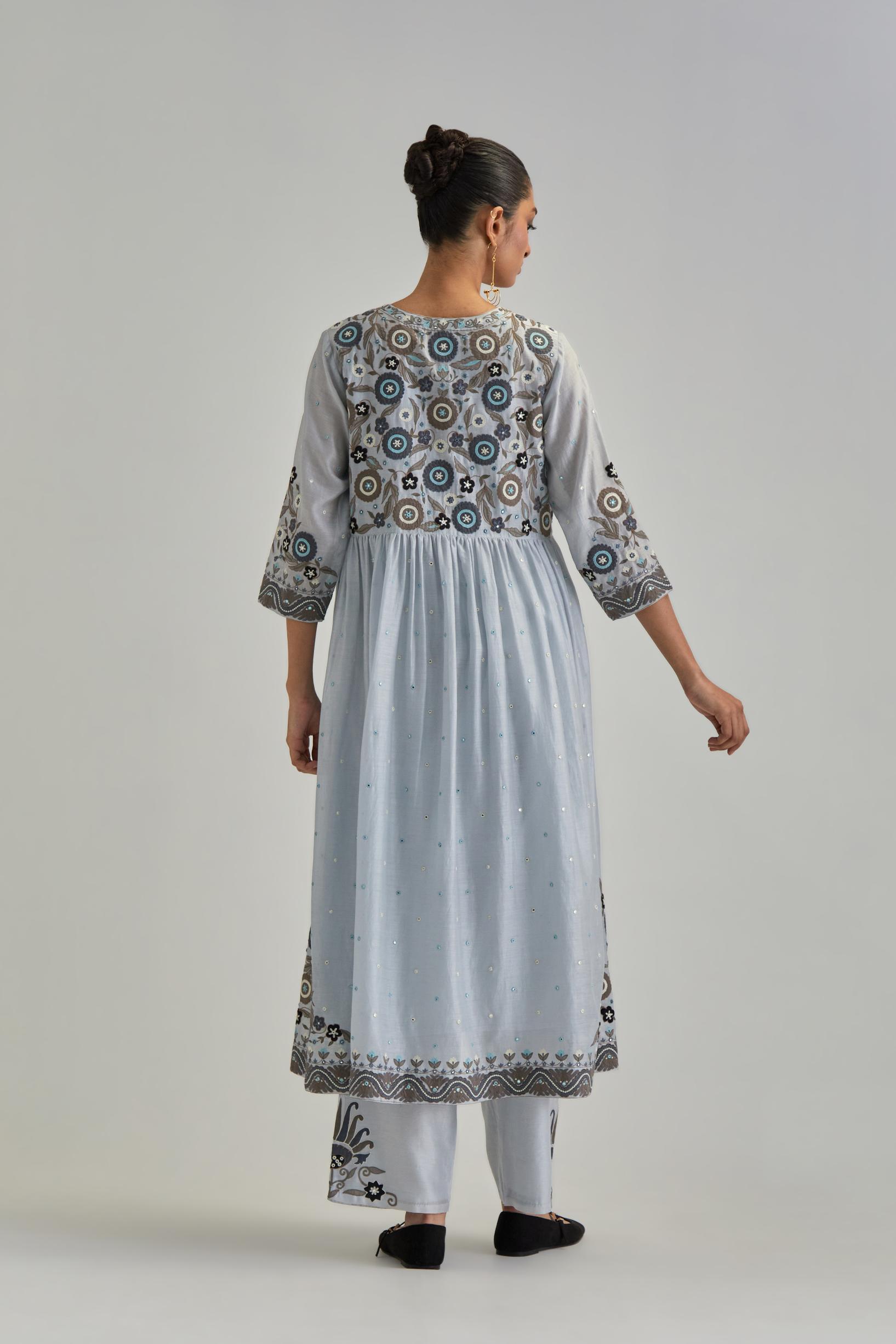 Blue silk Chanderi kurta-dress set with a wavy high-waist and fine gathers. The yoke is fully embroidered with earthy coloured circular appliqué and Aari thread work.