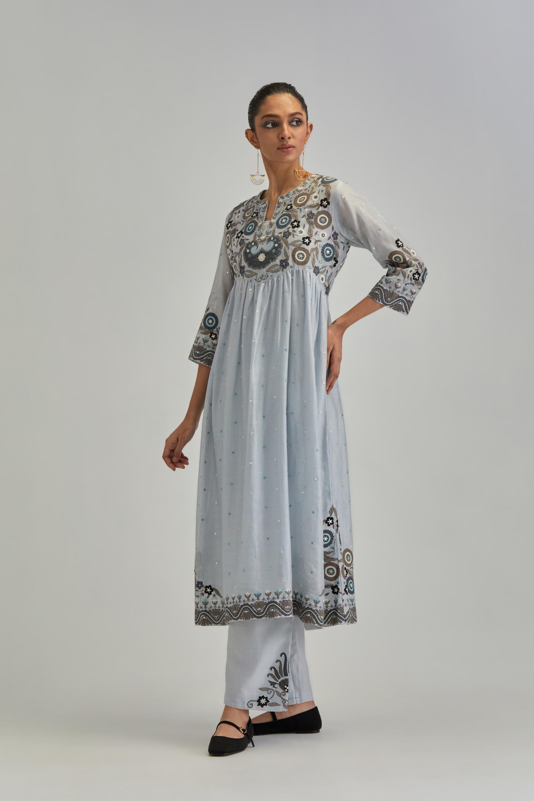 Blue silk Chanderi kurta-dress set with a wavy high-waist and fine gathers. The yoke is fully embroidered with earthy coloured circular appliqué and Aari thread work.