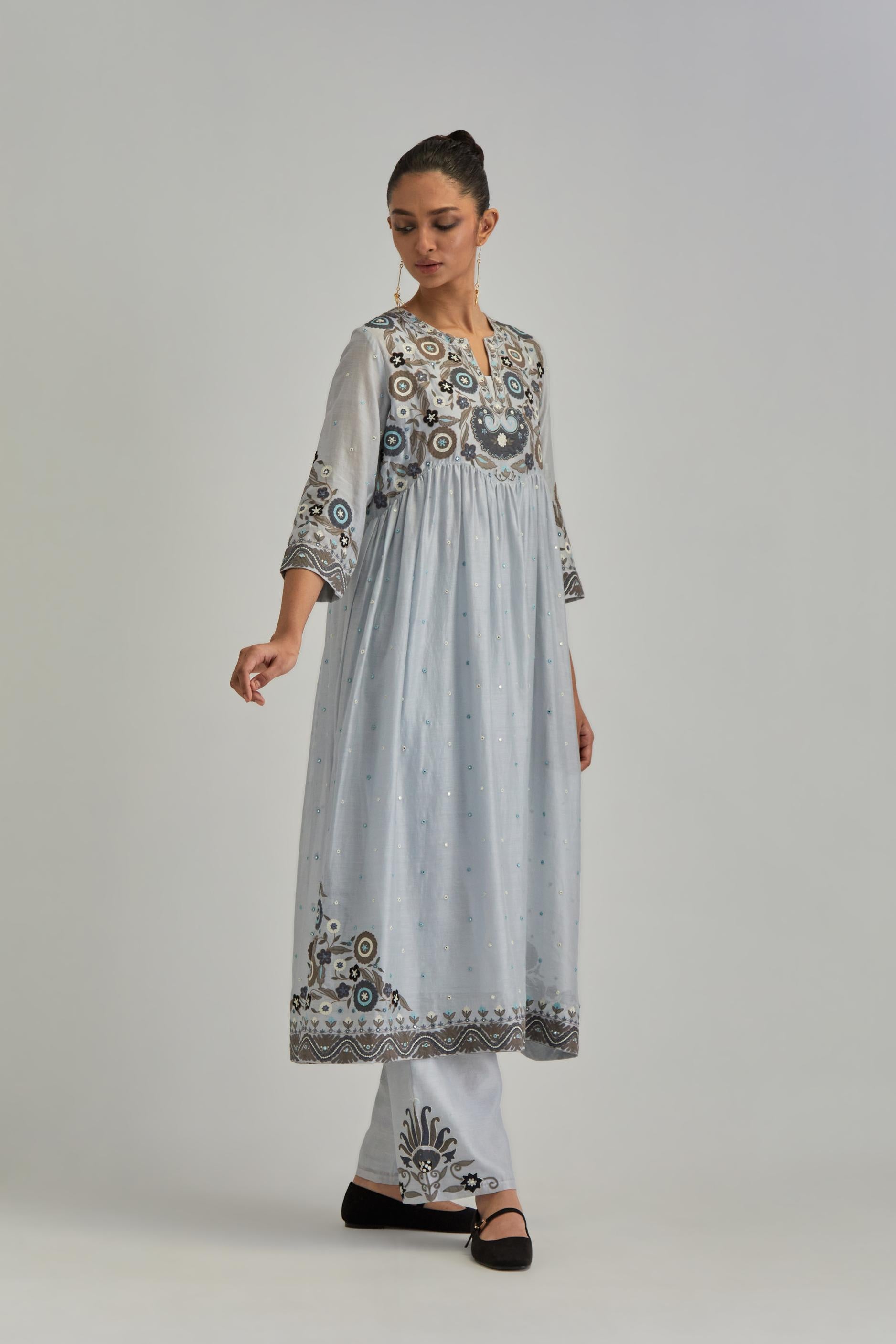 Blue silk Chanderi kurta-dress set with a wavy high-waist and fine gathers. The yoke is fully embroidered with earthy coloured circular appliqué and Aari thread work.