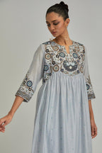 Blue silk Chanderi kurta-dress set with a wavy high-waist and fine gathers. The yoke is fully embroidered with earthy coloured circular appliqué and Aari thread work.