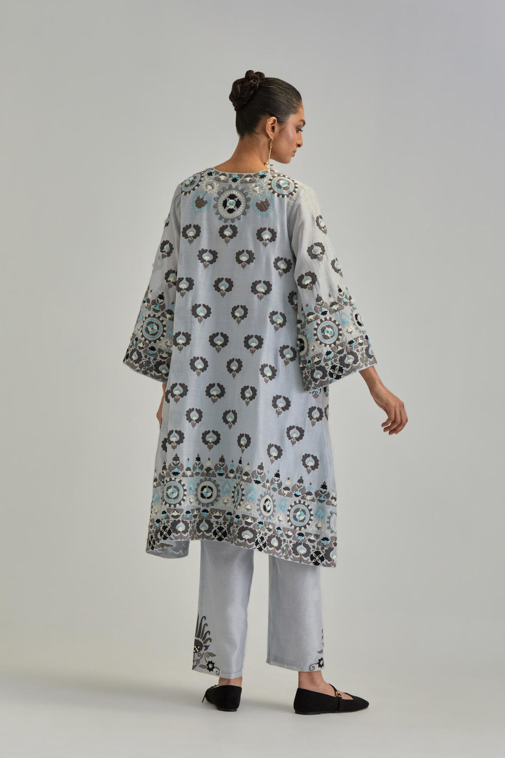 Blue silk Chanderi straight hem mid-length abha style kurta set with bold appliqué embroidery along with earthy-coloured Aari thread work and tassels.