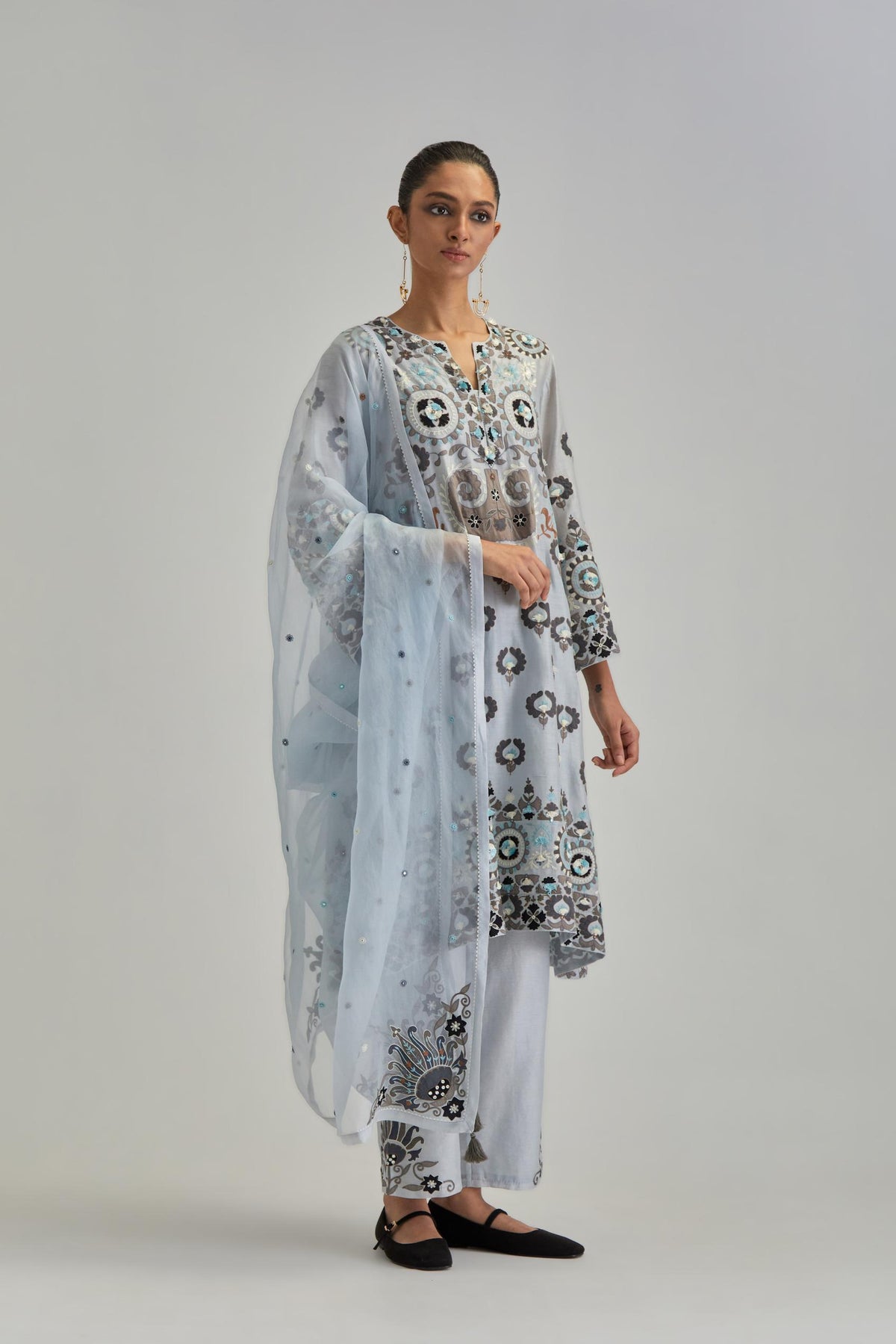 Blue silk Chanderi straight hem mid-length abha style kurta set with bold appliqué embroidery along with earthy-coloured Aari thread work and tassels.