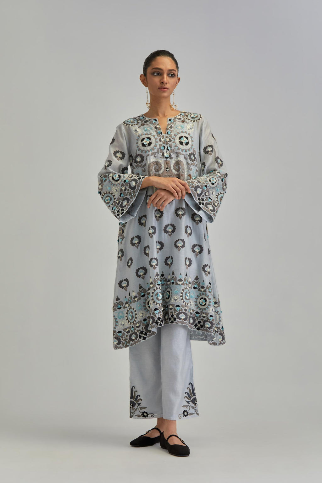 Blue silk Chanderi straight hem mid-length abha style kurta set with bold appliqué embroidery along with earthy-coloured Aari thread work and tassels.