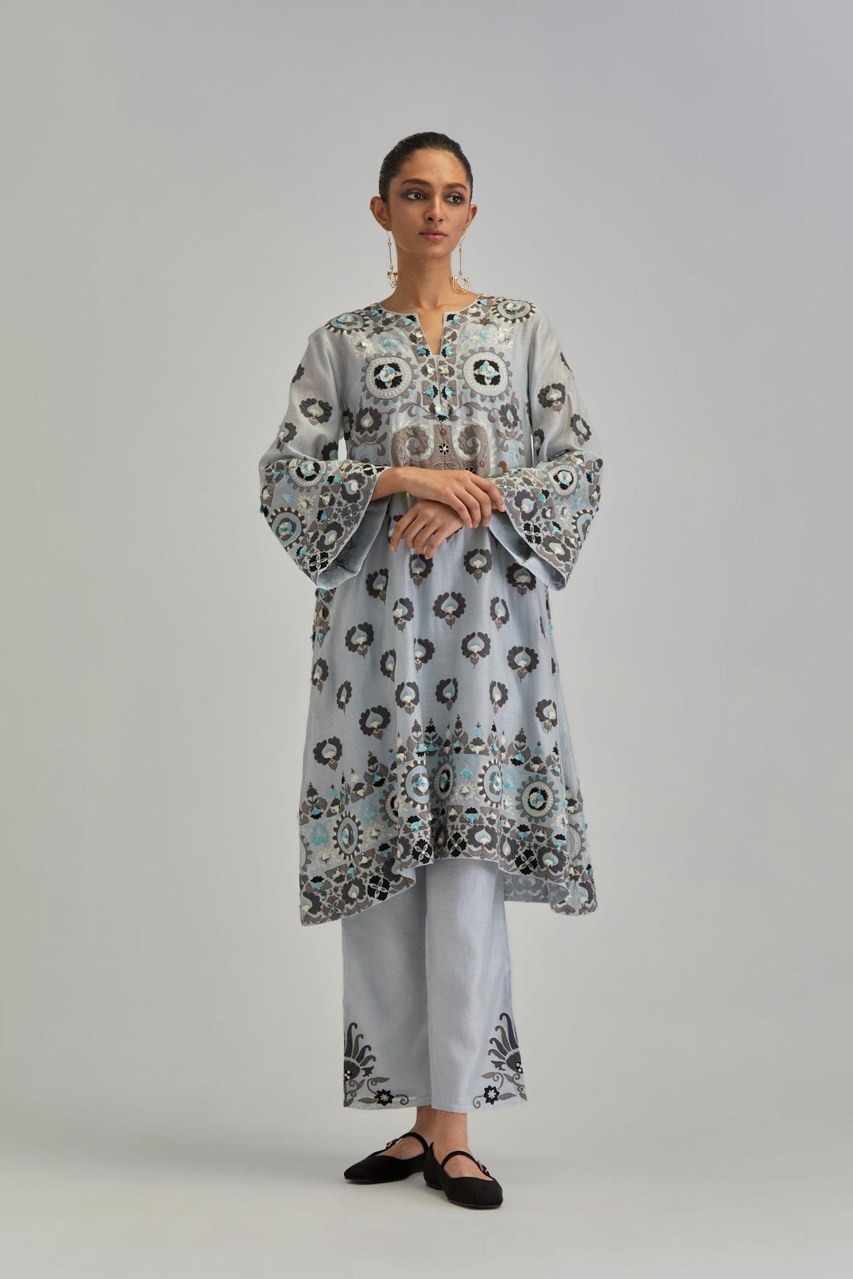 Blue silk Chanderi straight hem mid-length abha style kurta set with bold appliqué embroidery along with earthy-coloured Aari thread work and tassels.