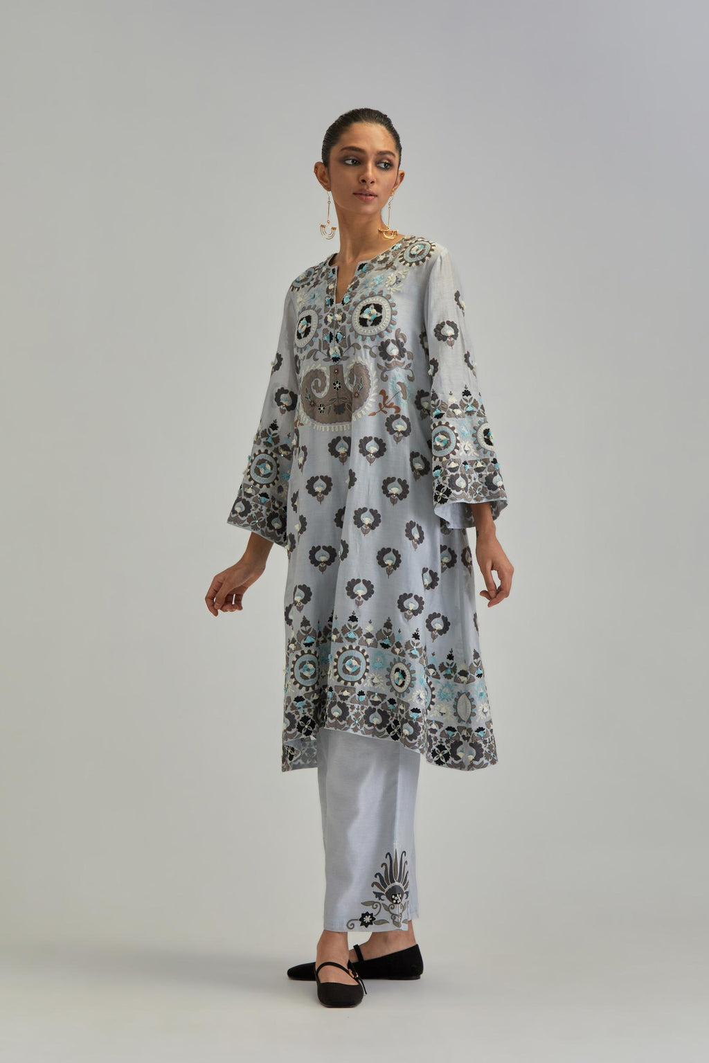 Blue silk Chanderi straight hem mid-length abha style kurta set with bold appliqué embroidery along with earthy-coloured Aari thread work and tassels.