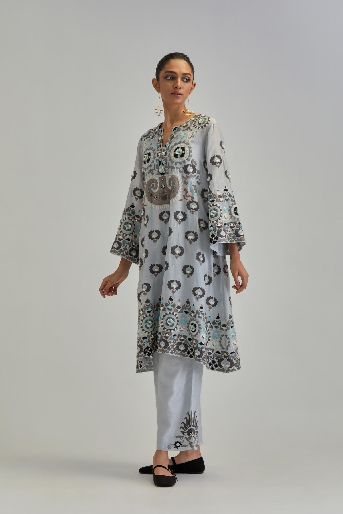 Blue silk Chanderi straight hem mid-length abha style kurta set with bold appliqué embroidery along with earthy-coloured Aari thread work and tassels.