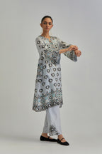 Blue silk Chanderi straight hem mid-length abha style kurta set with bold appliqué embroidery along with earthy-coloured Aari thread work and tassels.