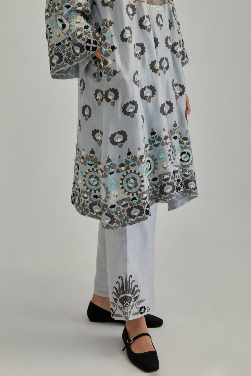 Blue silk Chanderi straight hem mid-length abha style kurta set with bold appliqué embroidery along with earthy-coloured Aari thread work and tassels.