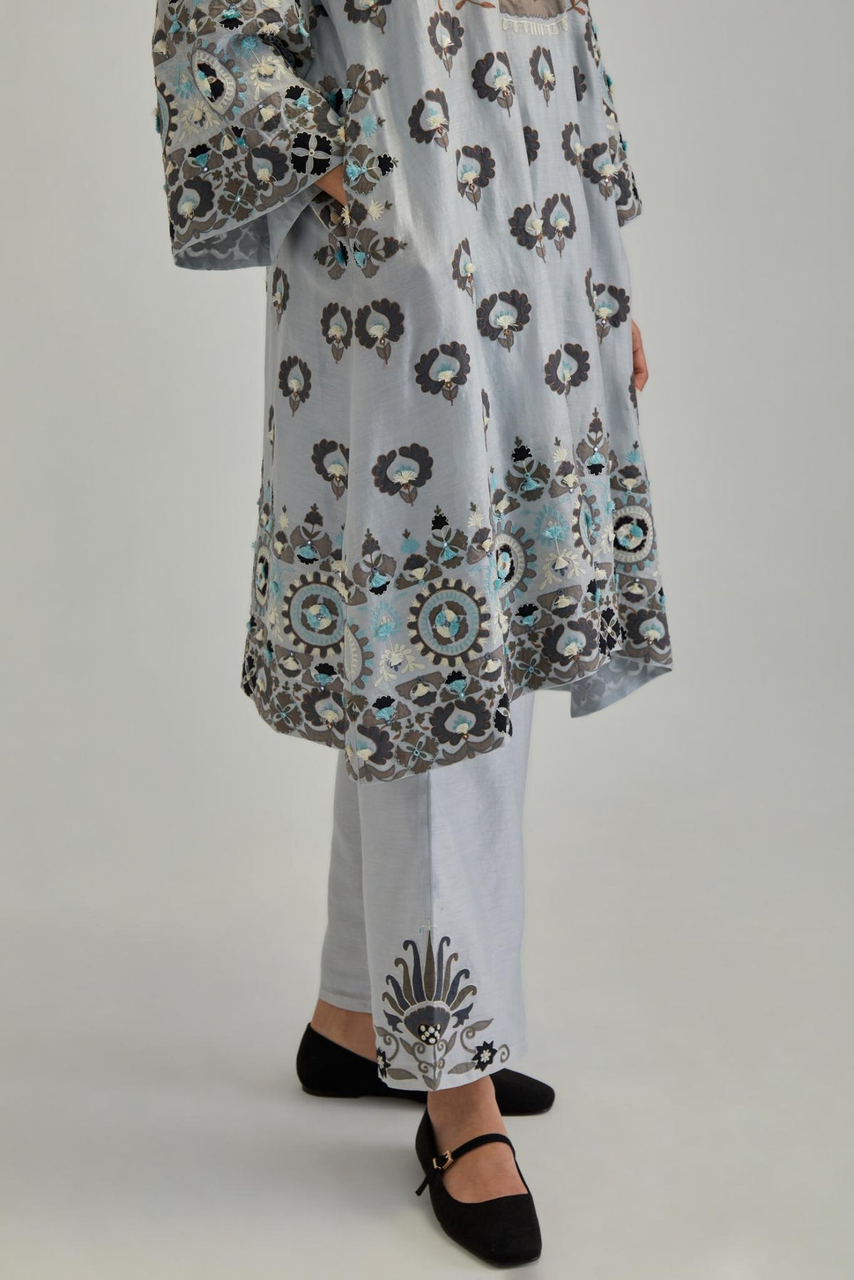 Blue silk Chanderi straight hem mid-length abha style kurta set with bold appliqué embroidery along with earthy-coloured Aari thread work and tassels.