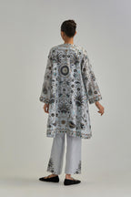 Blue short front open A-line jacket, fully embroidered with bold appliqué flowers, earthy-coloured Aari thread work and silk tassels, paired with Blue silk Chanderi straight pants with earthy coloured appliqué at hem.