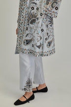 Blue short front open A-line jacket, fully embroidered with bold appliqué flowers, earthy-coloured Aari thread work and silk tassels, paired with Blue silk Chanderi straight pants with earthy coloured appliqué at hem.