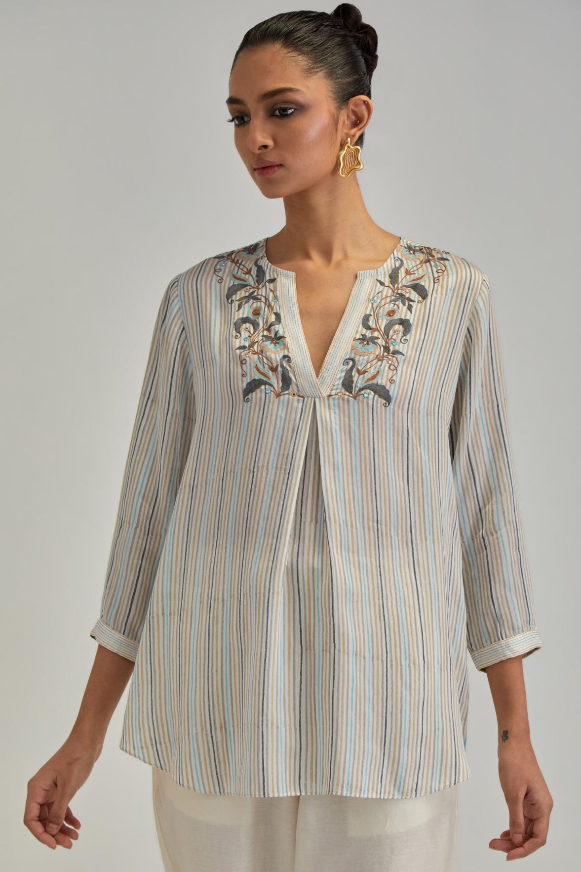 Off White short top with thin multi-coloured stripe hand block print and earthy coloured Aari thread embroidery, paired with Off White silk Chanderi straight pants with mirror work, highlighted with earthy coloured thread work.