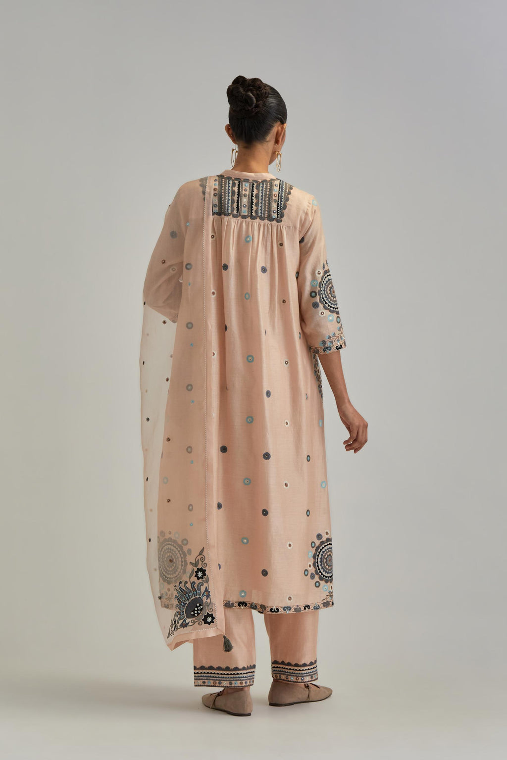 Pink silk Chanderi gathered kurta-dress set with appliqué stripes along with aari thread work flowers and floral trellises along with a circular appliqued motif.
