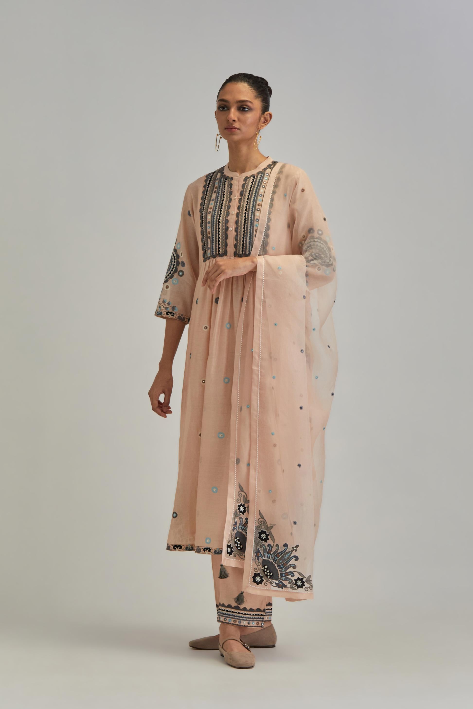Pink silk Chanderi gathered kurta-dress set with appliqué stripes along with aari thread work flowers and floral trellises along with a circular appliqued motif.