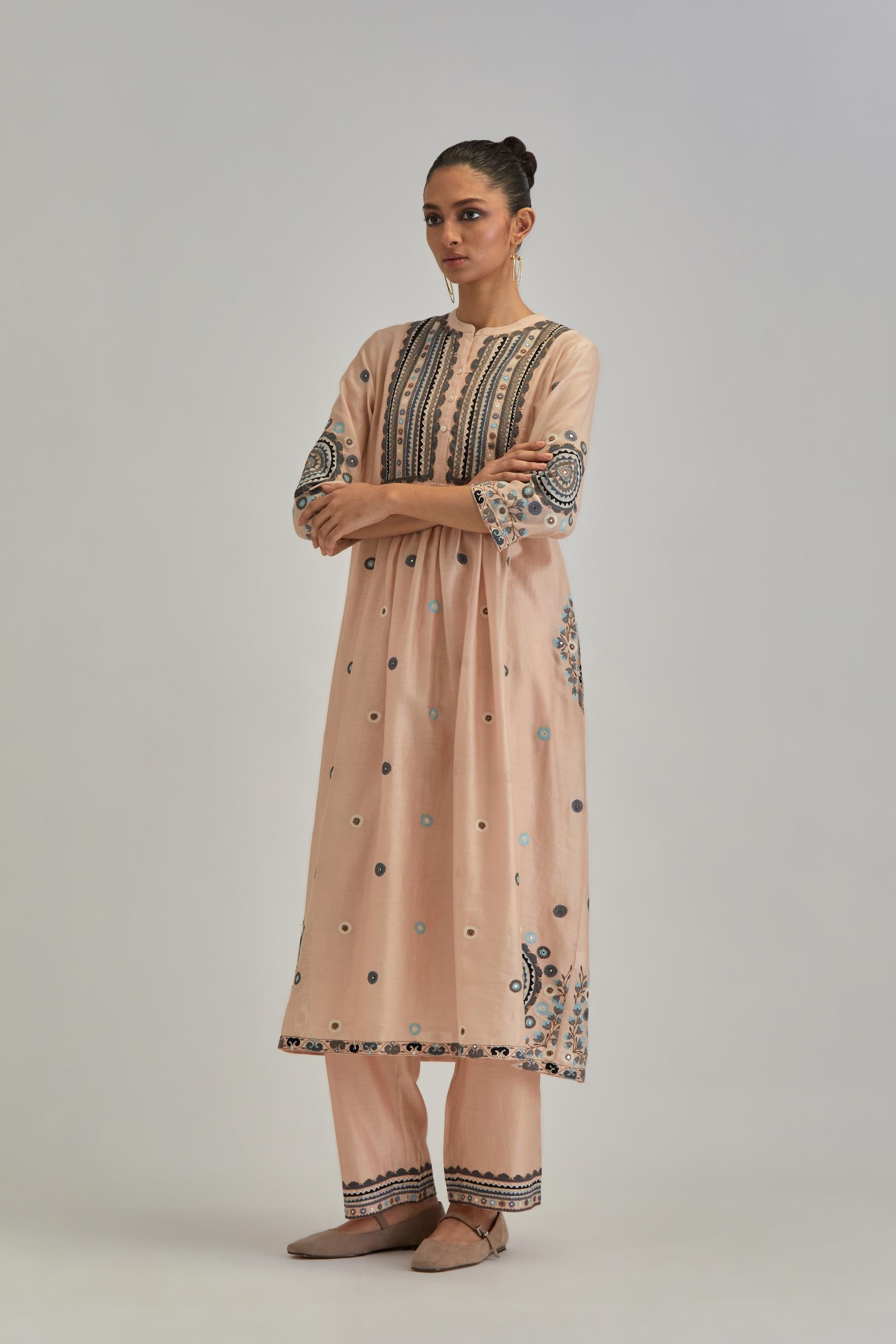 Pink silk Chanderi gathered kurta-dress set with appliqué stripes along with aari thread work flowers and floral trellises along with a circular appliqued motif.