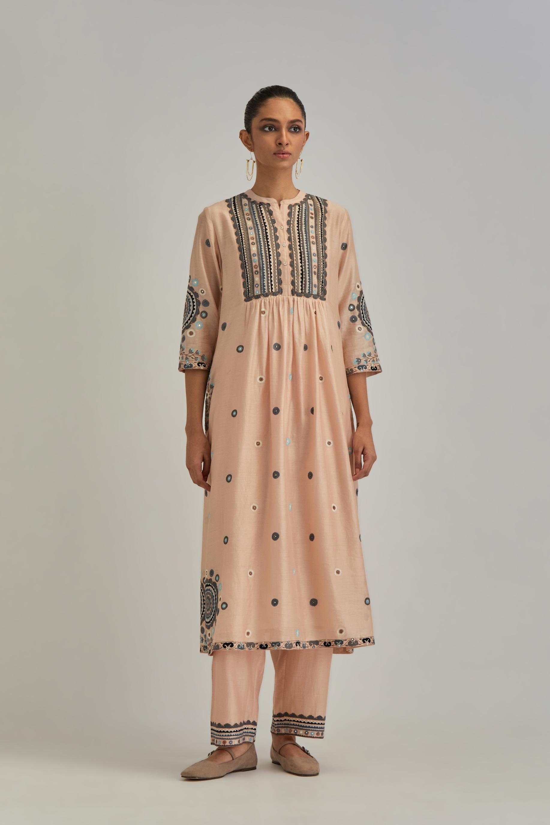 Pink silk Chanderi gathered kurta-dress set with appliqué stripes along with aari thread work flowers and floral trellises along with a circular appliqued motif.
