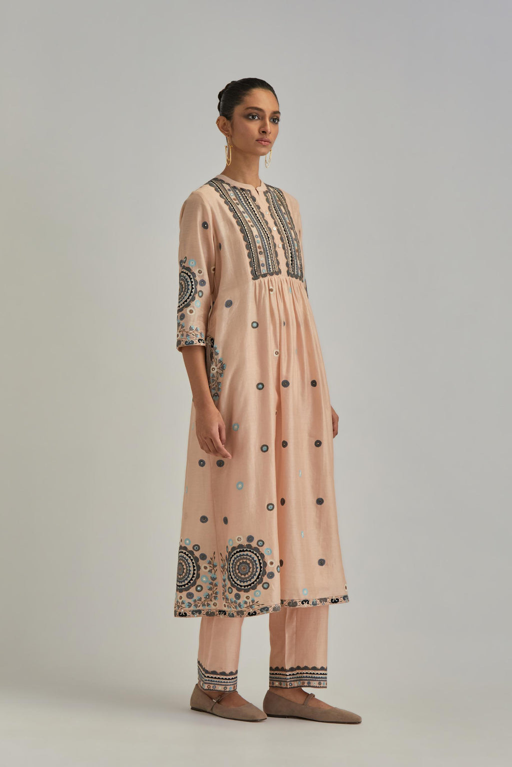 Pink silk Chanderi gathered kurta-dress set with appliqué stripes along with aari thread work flowers and floral trellises along with a circular appliqued motif.