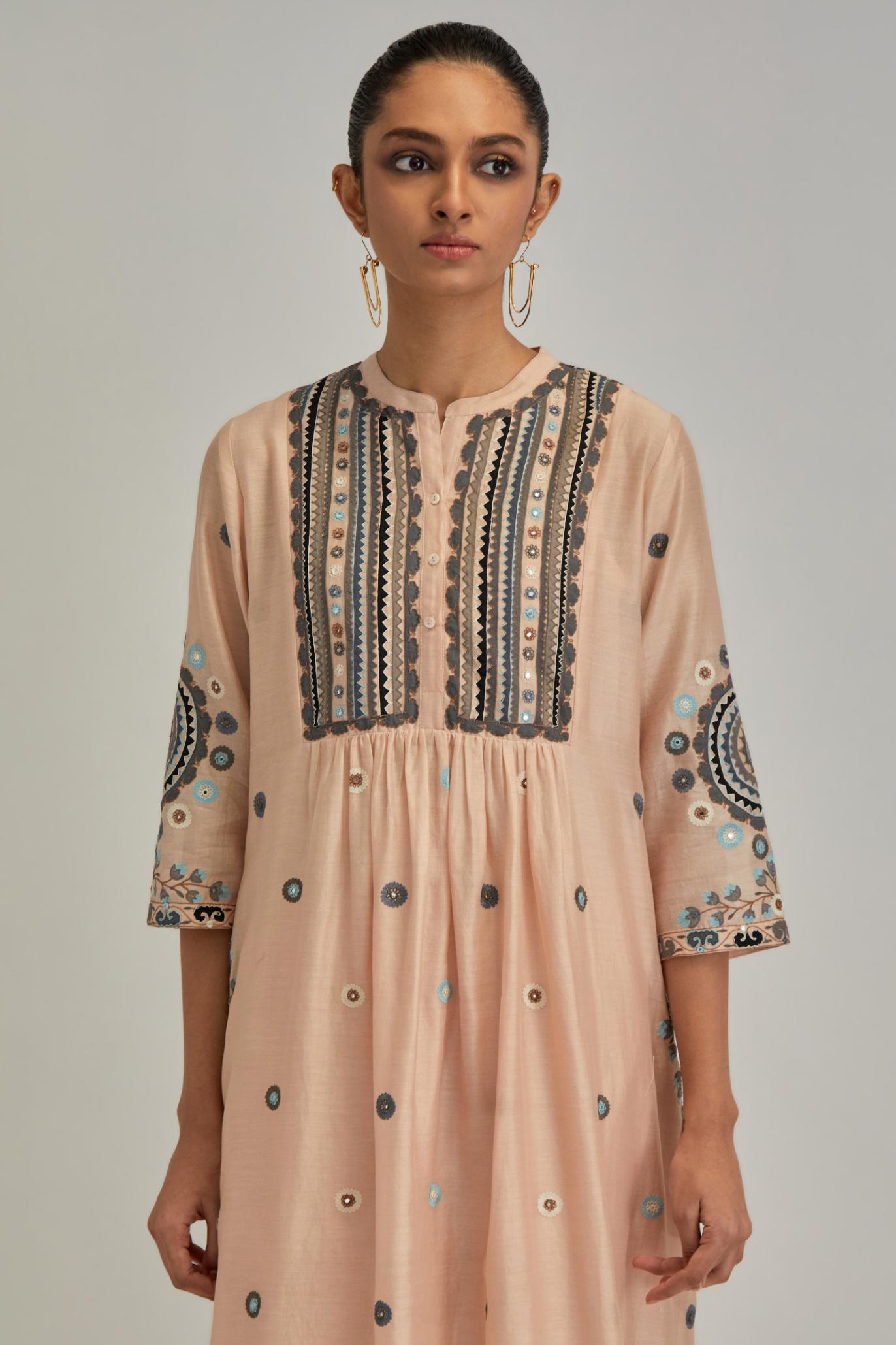 Pink silk Chanderi gathered kurta-dress set with appliqué stripes along with aari thread work flowers and floral trellises along with a circular appliqued motif.