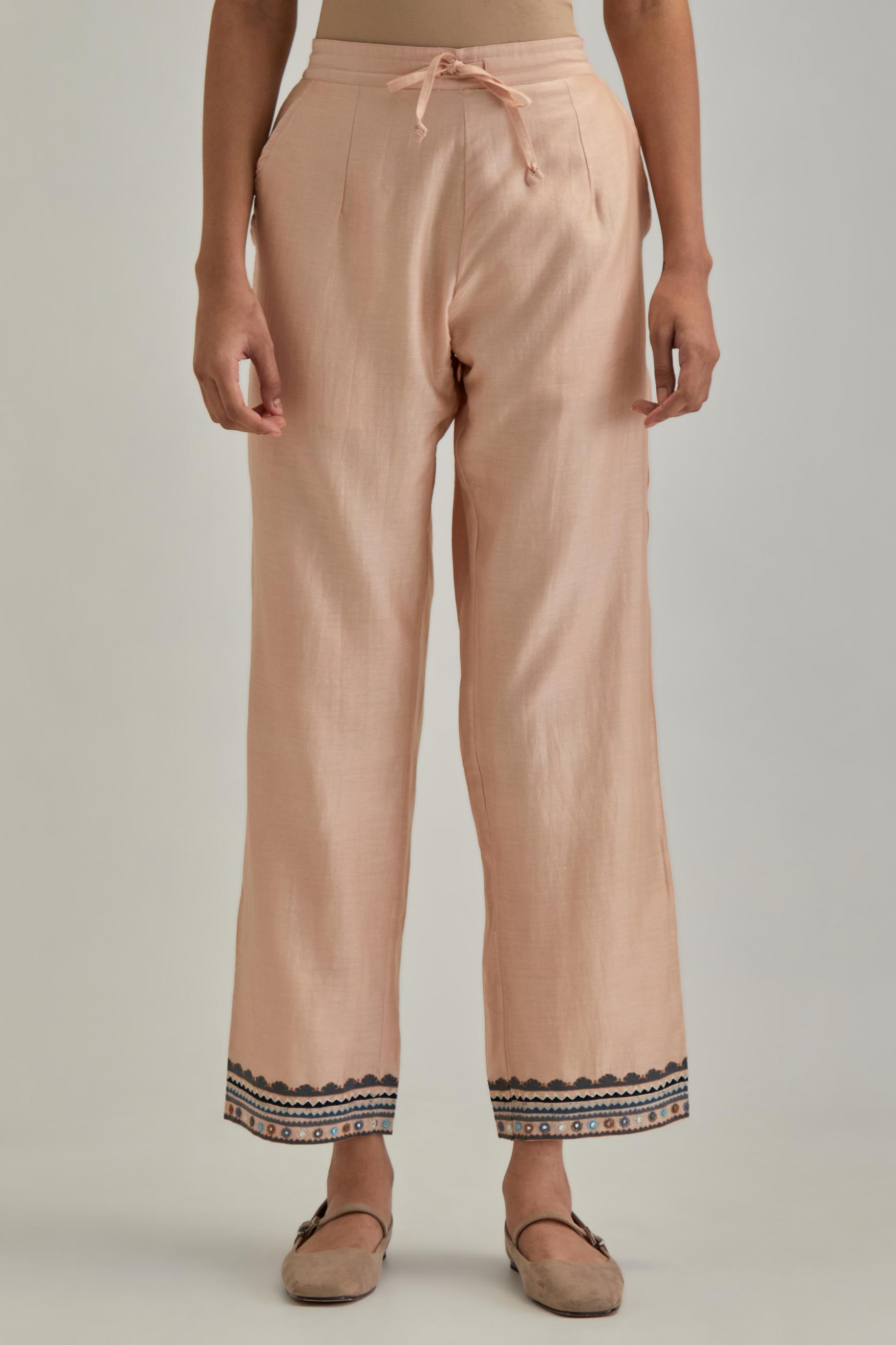 Pink silk Chanderi straight pants with earthy coloured applique and Aari thread work at hem.