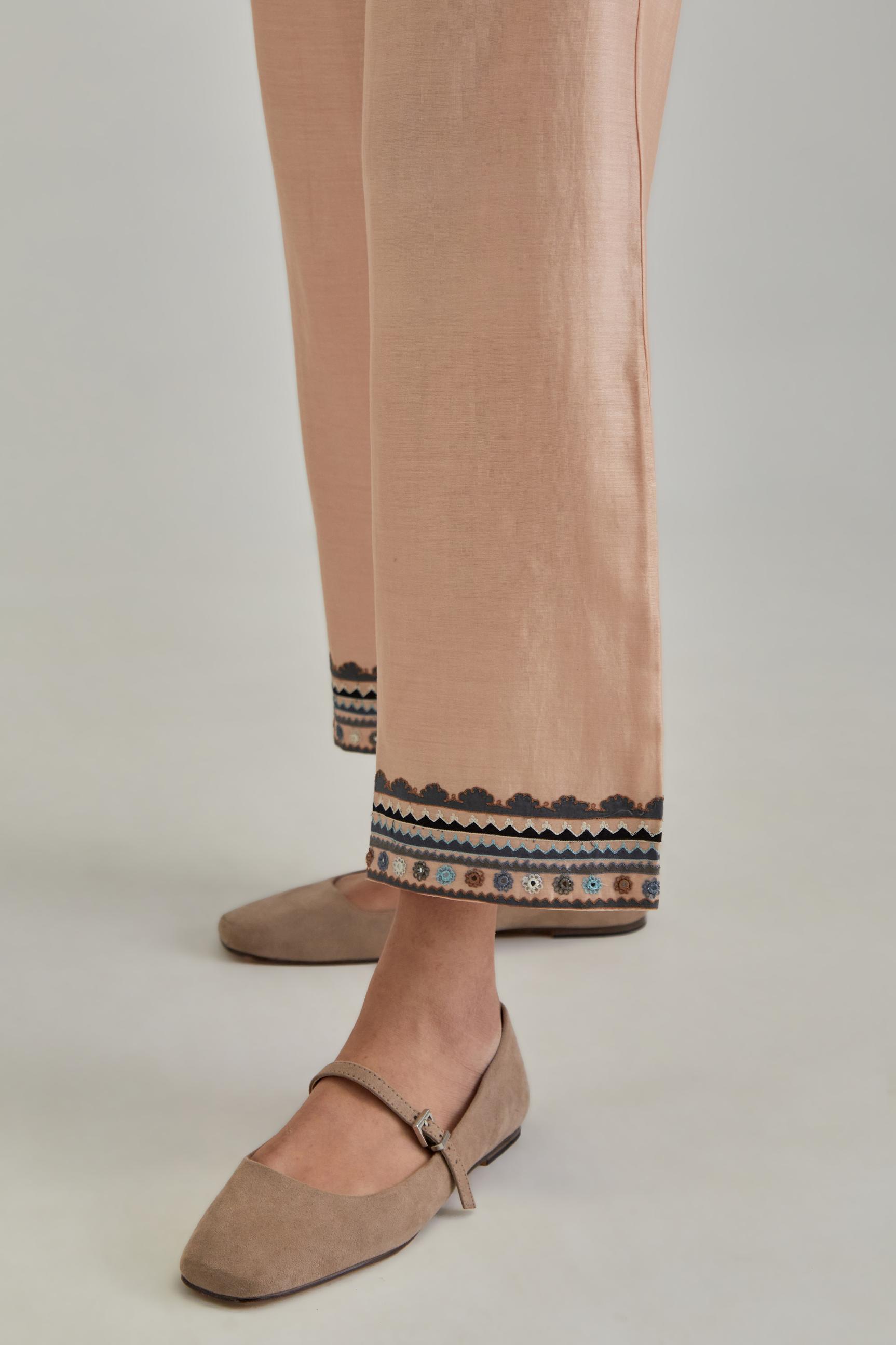 Pink silk Chanderi straight pants with earthy coloured applique and Aari thread work at hem.