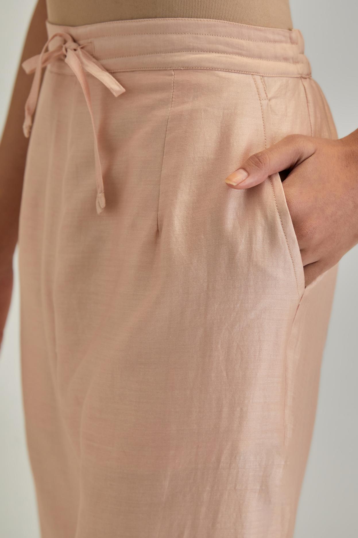 Pink silk Chanderi straight pants with earthy coloured applique and Aari thread work at hem.