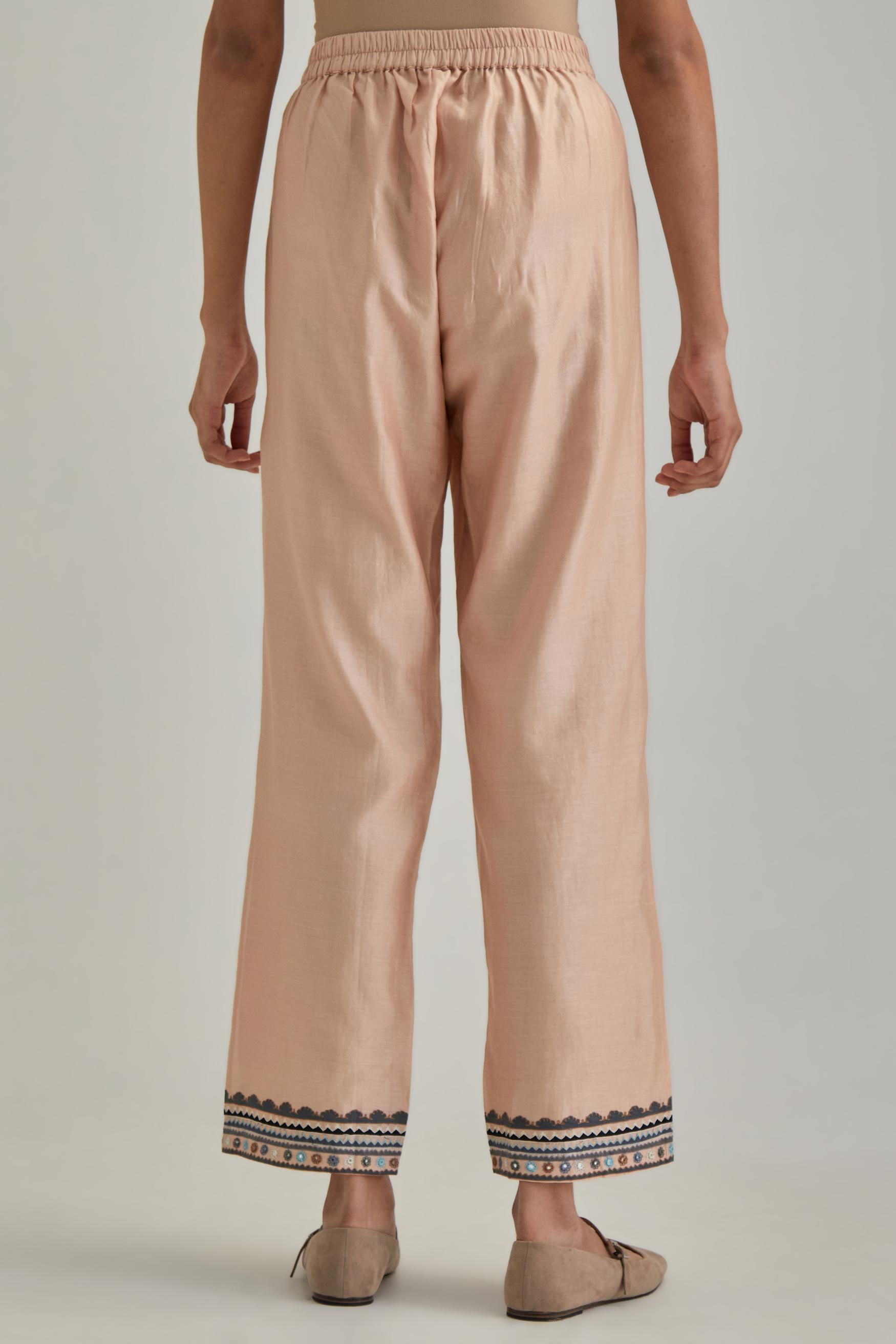 Pink silk Chanderi straight pants with earthy coloured applique and Aari thread work at hem.