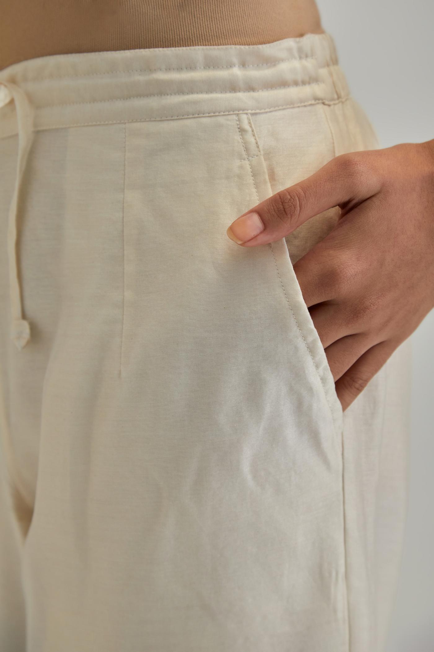 Off White silk Chanderi straight pants with mirror work, highlighted with earthy coloured thread work.