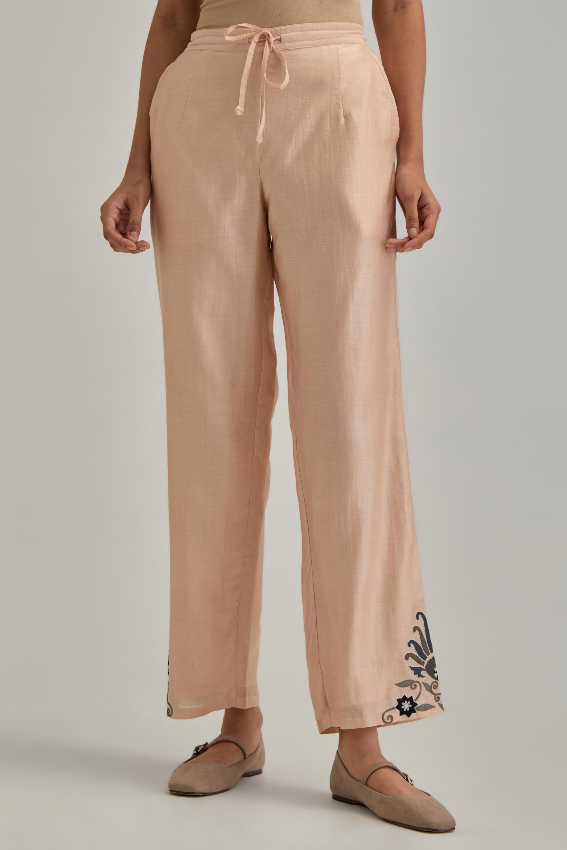 Pink silk Chanderi straight pants with earthy coloured appliqué at hem.