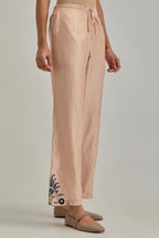 Pink silk Chanderi straight pants with earthy coloured appliqué at hem.