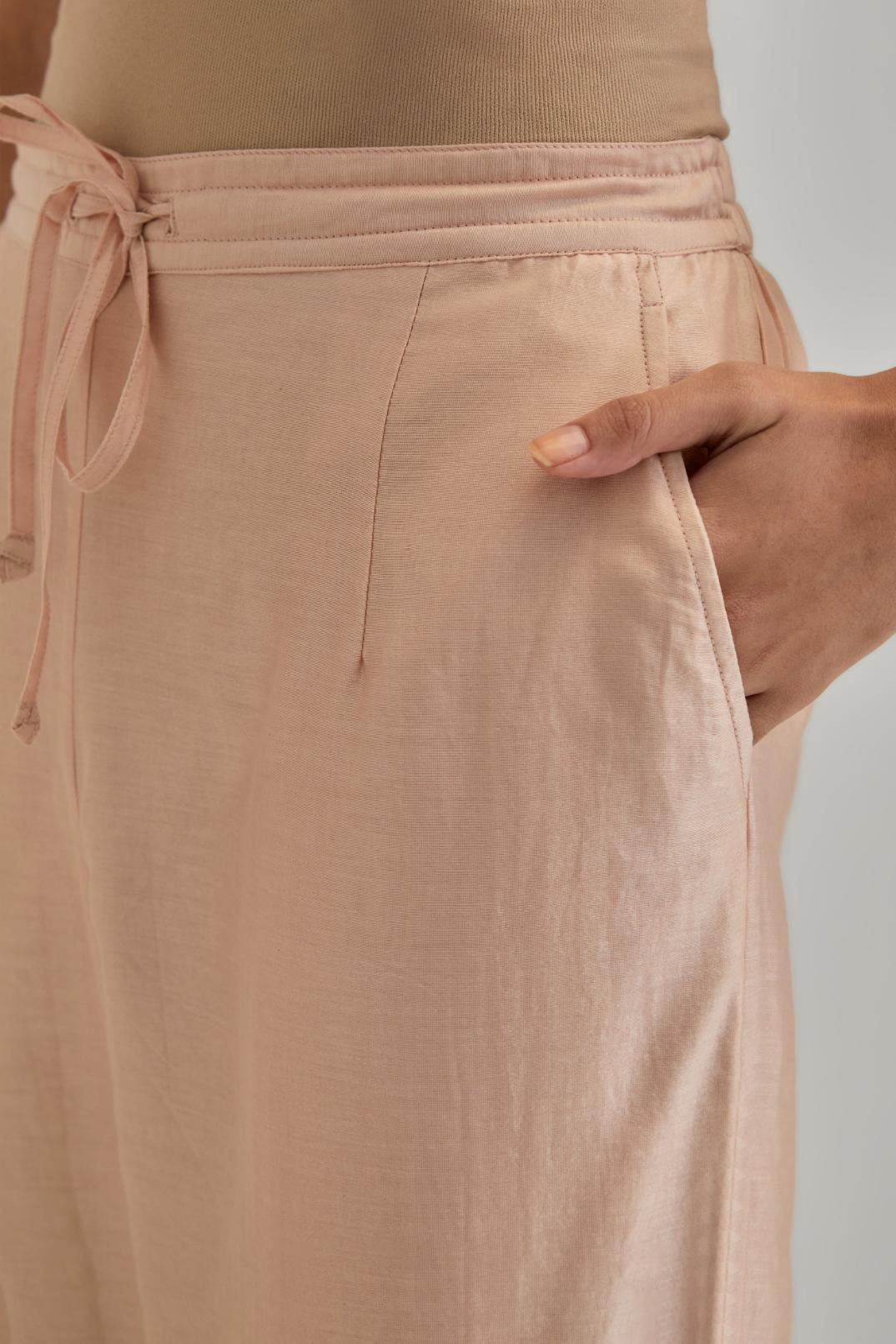 Pink silk Chanderi straight pants with earthy coloured appliqué at hem.