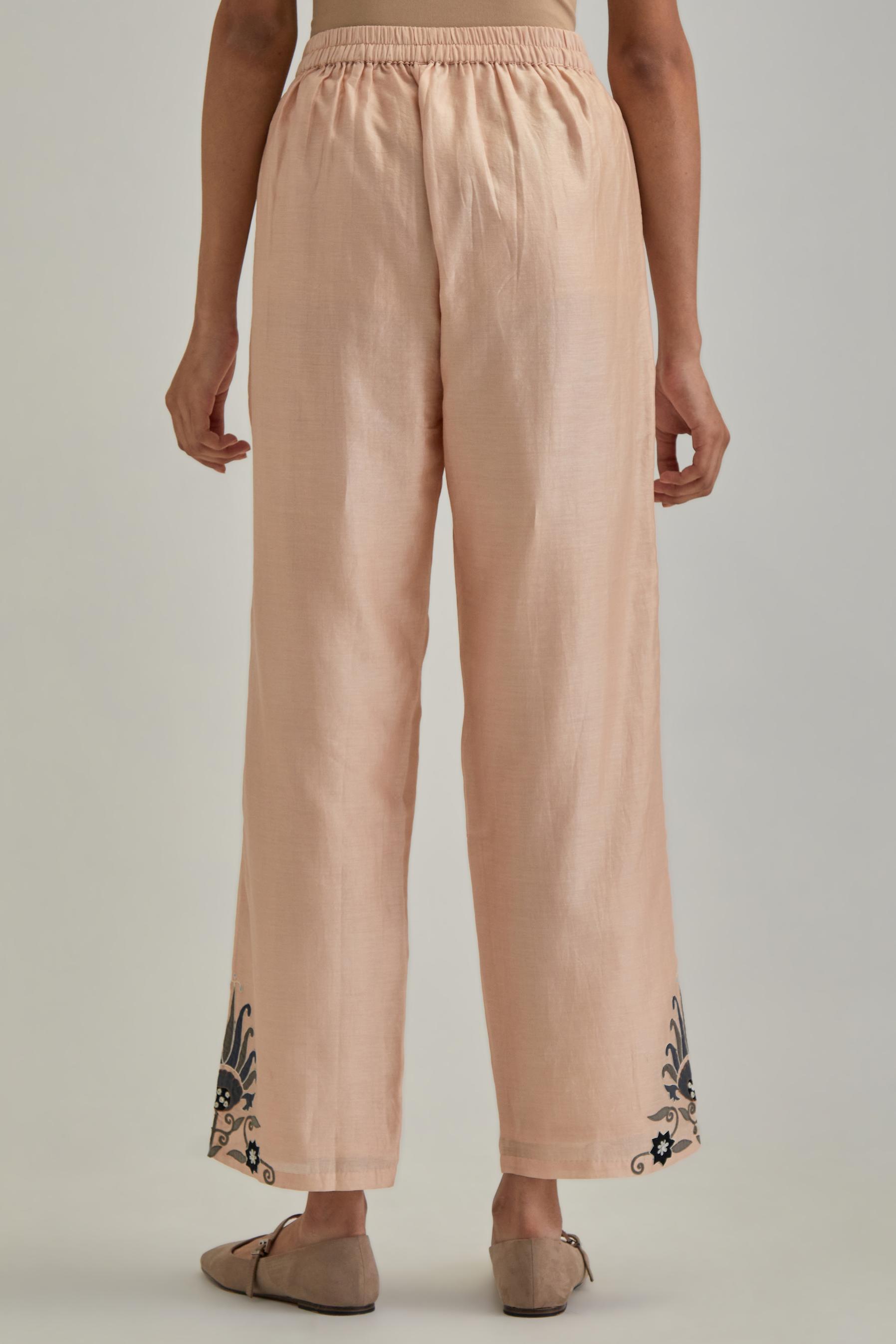 Pink silk Chanderi straight pants with earthy coloured appliqué at hem.