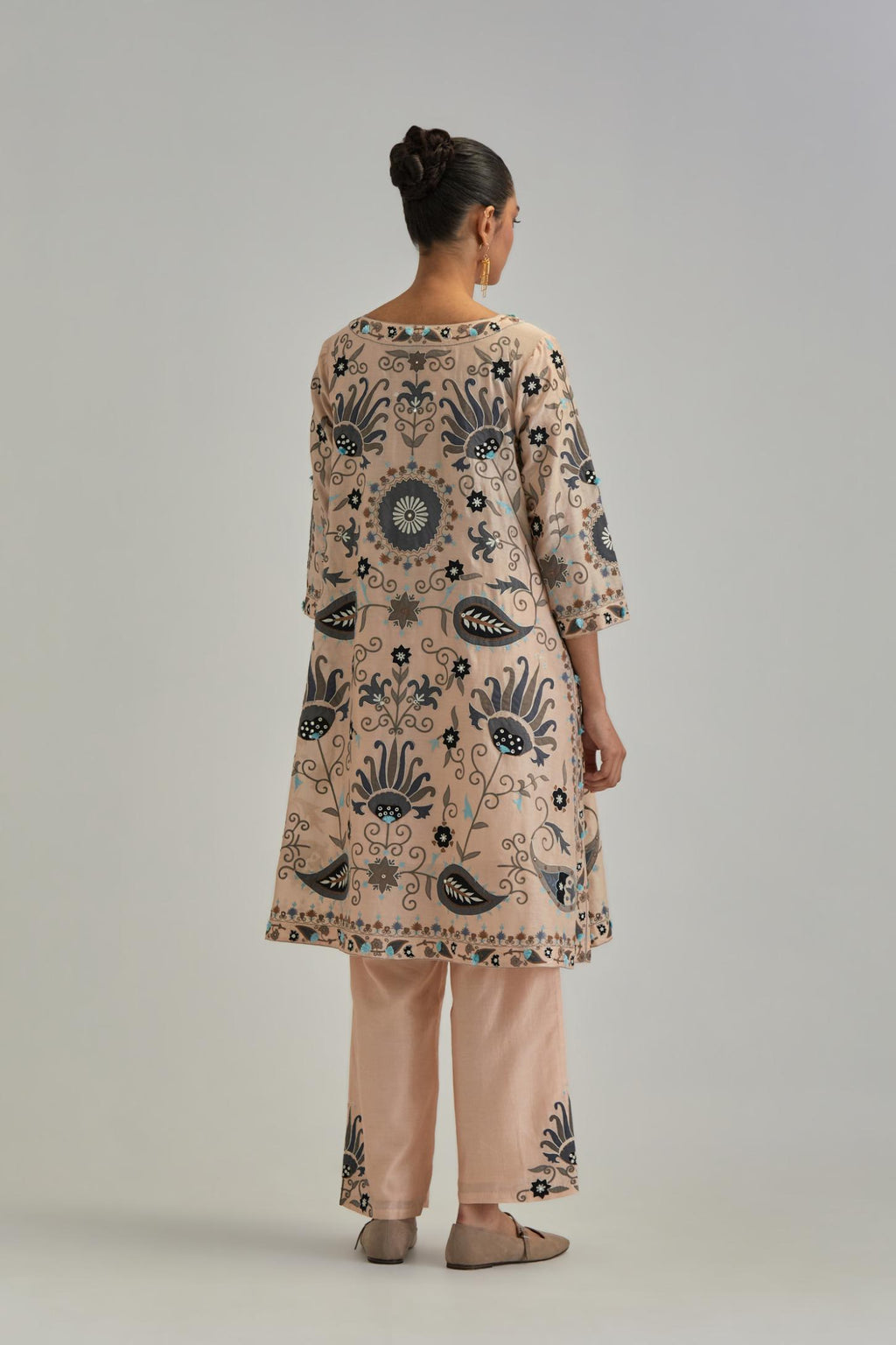 Pink short A-line silk Chanderi kurta set, fully embroidered with earthy coloured appliqué with Aari thread work and silk tassels.