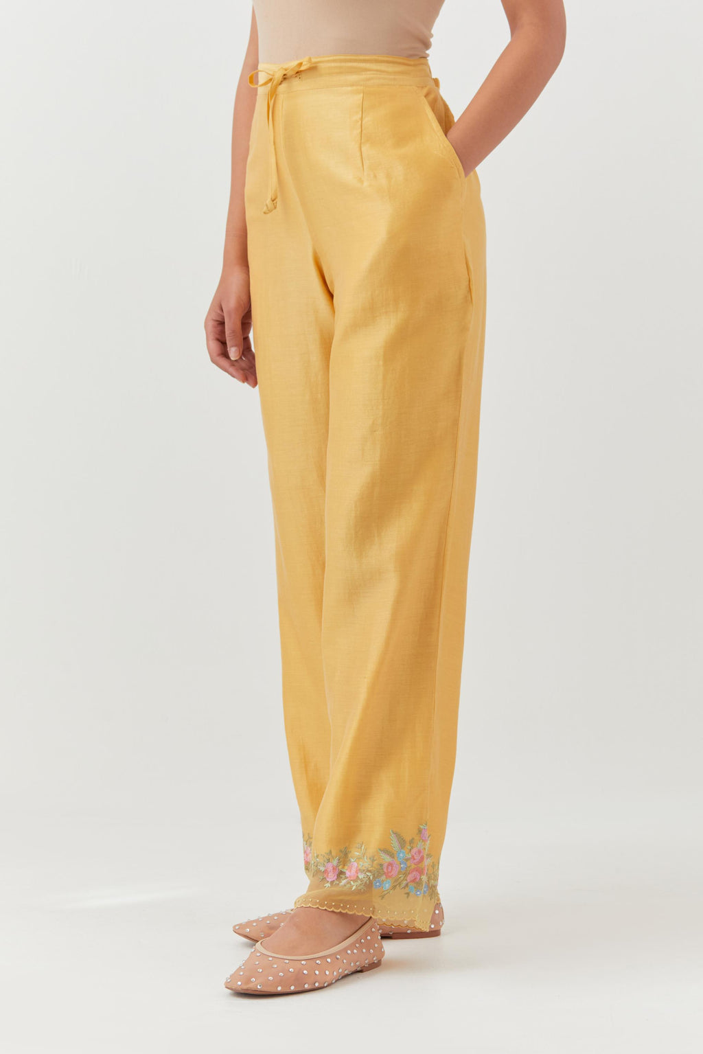 Yellow silk chanderi straight pants with a broad organza scalloped hem, highlighted with embroidered rose flower bunches and beads.