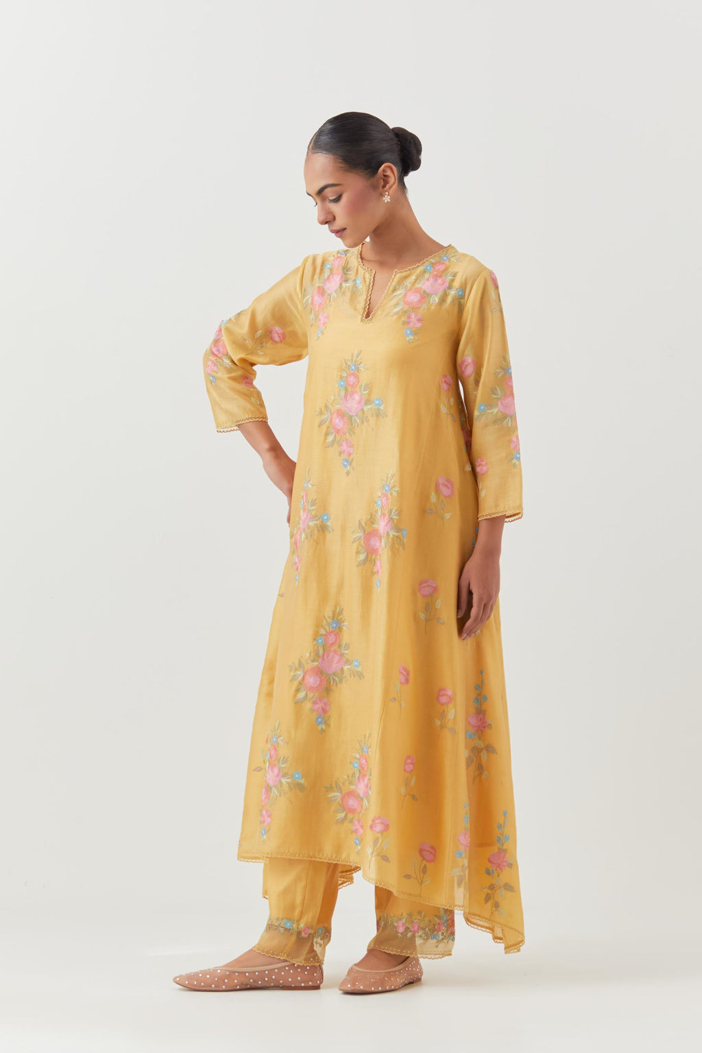 Yellow silk chanderi easy fit, asymmetric hem, paneled kurta set with all-over thread embroidered roses, highlighted with scalloped organza at the edges with contrast beads.