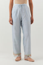 Blue silk chanderi straight pants with a broad organza scalloped hem, highlighted with embroidered rose flower bunches and beads.