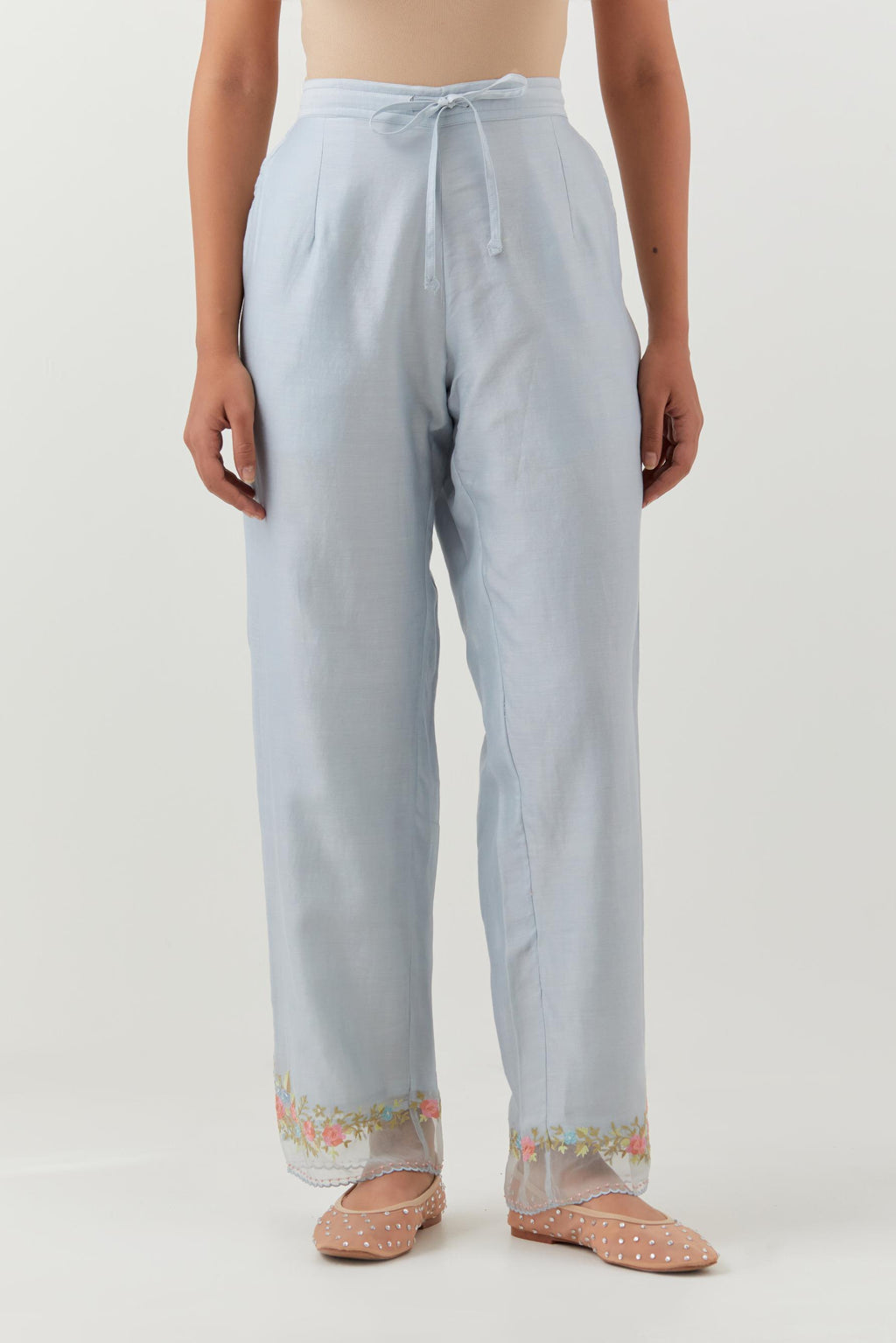 Blue silk chanderi straight pants with a broad organza scalloped hem, highlighted with embroidered rose flower bunches and beads.