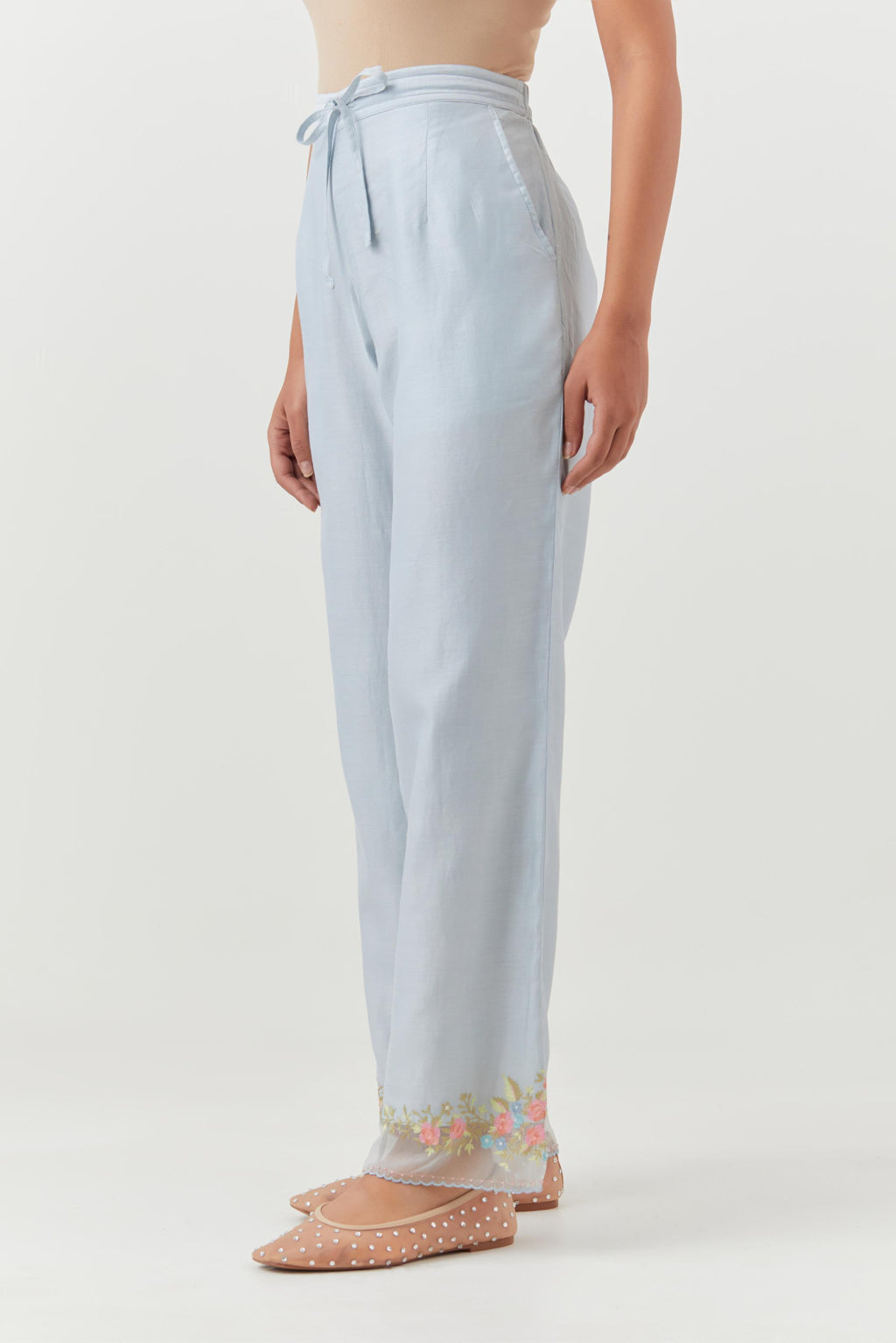 Blue silk chanderi straight pants with a broad organza scalloped hem, highlighted with embroidered rose flower bunches and beads.